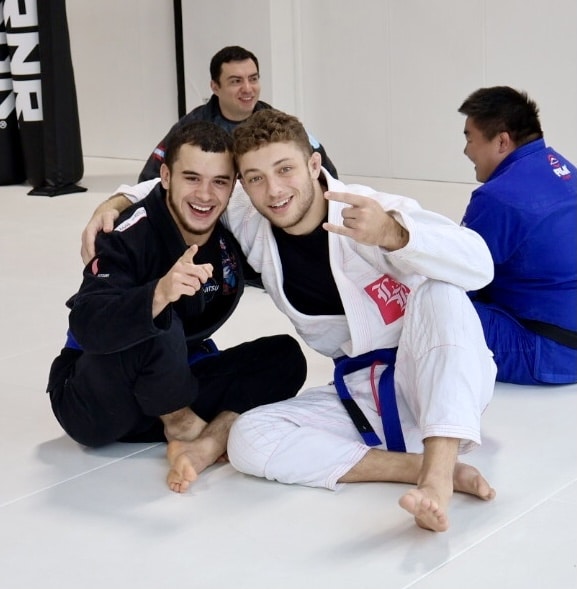 Northside Jiu Jitsu students smiling on mats after BJJ class.