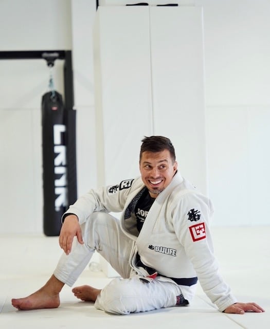 North Side Brazilian Jiu Jitsu student sitting on mat wearing gi uniform.